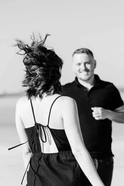 A black and white photo of a celebrity couple dancing intimately at their wedding reception. The background is softly blurred, creating a romantic and private atmosphere. The bride is in a vintage gown and the groom is in a classic tuxedo.