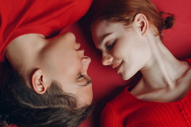 A close-up shot of a celebrity couple embracing on a red carpet, their faces radiating happiness and affection. The focus is on their genuine emotional connection.
