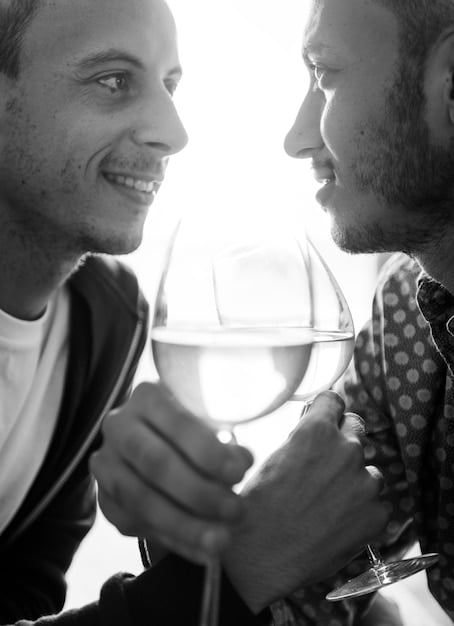 A close-up shot of two A-list actors laughing and sharing a drink at an award show after-party, capturing a candid and genuine moment between them. The background is subtly blurred to maintain focus on the subjects.