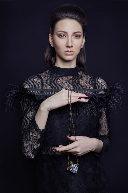 A close-up shot of a woman's formal black-tie attire, including a floor-length gown, elegant jewelry, and perfectly styled hair. The focus is on the details of the outfit and the overall impression of sophistication.