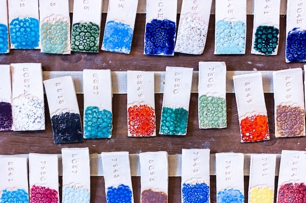 A photograph showcasing a diverse range of fabric swatches and color palettes, including vibrant jewel tones, soft pastels, and metallic finishes, illustrating the variety and innovation in material choices for red carpet designs.